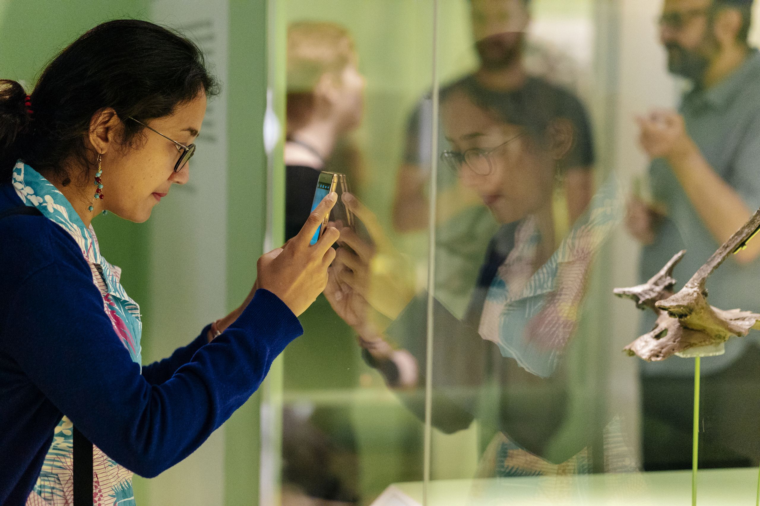 A visitor takes a photo of an antler headdress