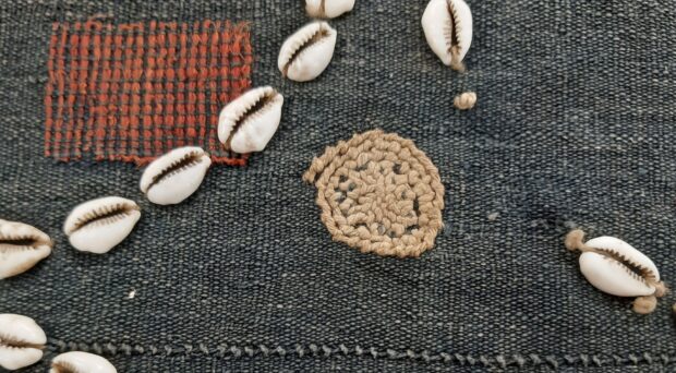 Spiral repair on a Naga body cloth decorated with cowrie shells and red dog’s hair. MAA 1947.225