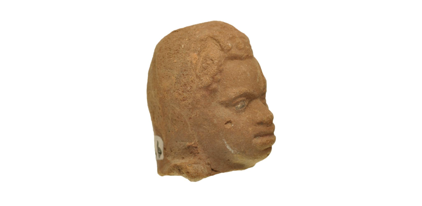 side view of terracotta figurine head, looking right