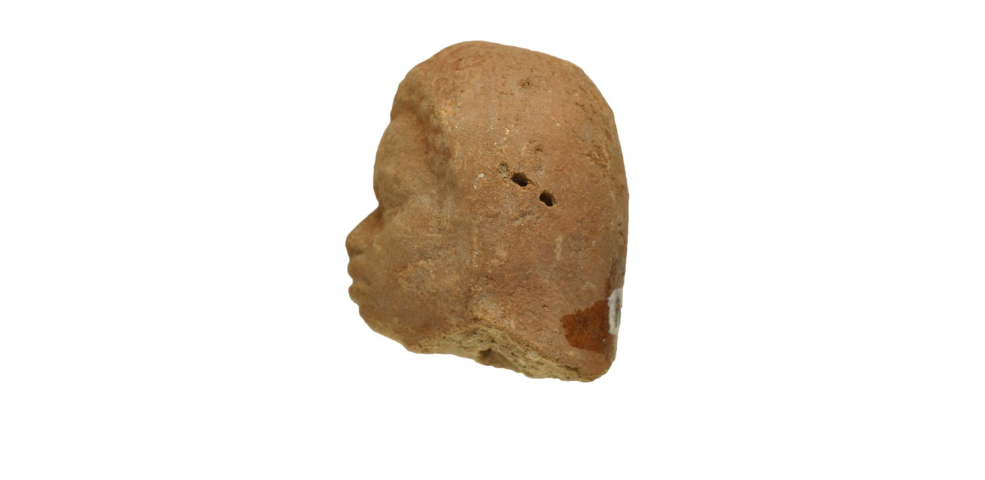 Side view of terracotta figurine head, looking left