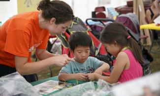 Children do craft activity in museum tent
