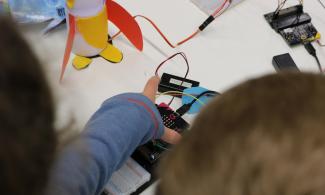 child playing with makey makey device