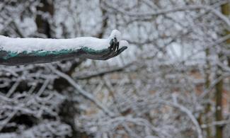 Detail of a snow covered statue's arm