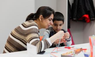 a woman and child taking part in an art activity 