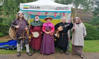 Group of historical reenactors dressed in assorted medieval costumes