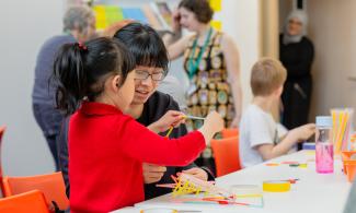 An adult and child at a table with craft materials