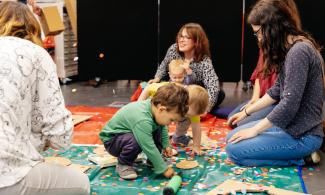 Children and adults on a play mat