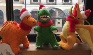 Soft toy dinosaurs with Santa hats and scarves