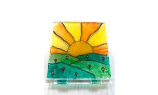 A sheet of acrylic, with a painted image of the sun and grass