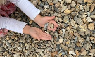 A child holding some pieces of gravel