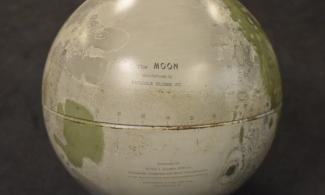 A moon globe, in grey and green with the words "the moon" visible.