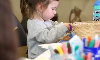 alt="a child sorts through art supplies"