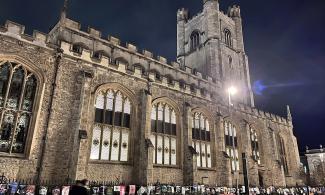 Great St Mary's Church building at night, lit up inside.