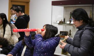 Young visitor in the Learning Gallery, using a telescope from the handling collection. 