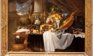 alt="image of DeHeem's banquet still life, showing a table with an abundance of exotic food and instruments"