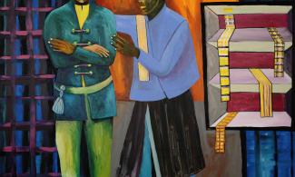 Two men in colourful clothing outside of a shop front.