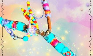A brightly decorated stick with thread and beads.