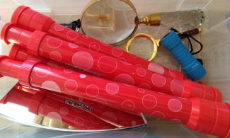 Box of telescopes, torches and other scientific equipment