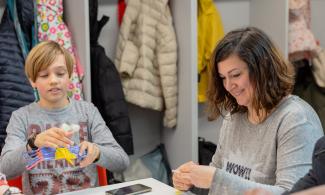 A woman and a child smiling during a workshop at Kettle's Yard