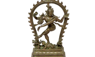 A small statue of a figure with four arms dancing under an arch of flames.