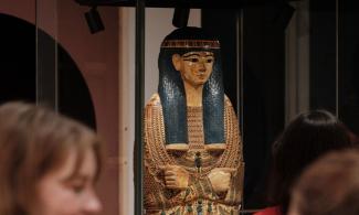 Visitors looking at a wooden Egyptian coffin at the Fitzwilliam's 'Made in Ancient Egypt' exhibition 
