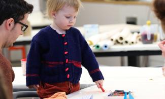 A child looking at drawings on a table in a workshop at Kettle's Yard.
