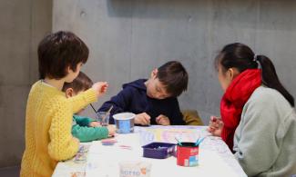 A woman and three children sat at a table during a workshop at Kettle's Yard.