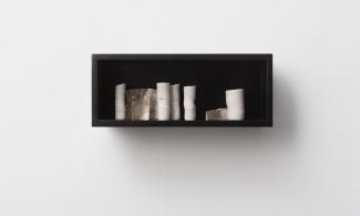 A black shelf filled with ceramic vessels.