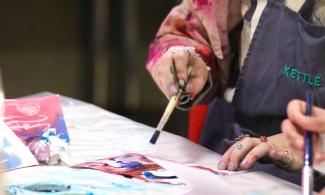 A woman painting in a workshop at Kettle's Yard.
