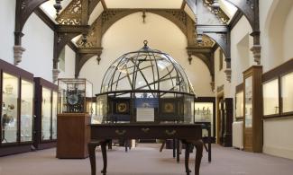 View of the museum grand orrery (planetarium) in the centre of a room with wooden arches.