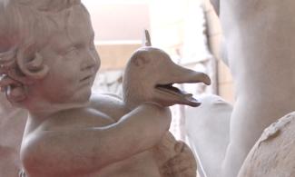 A sculpture of a boy holding a goose.