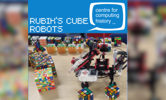 The image shows lots of Rubik's Cubes and the robot that is programmed to solve them.