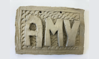 Clay tile with "Amy" carved into it