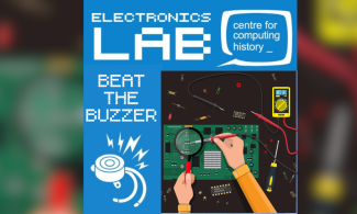 A poster shows hands testing a circuit board with multimeter probes, surrounded by electronic tools and components.