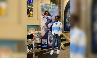 Hephzibah Akinwale next to a sign showing her book