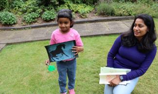 Child holding her artwork created using paints and gelli plates