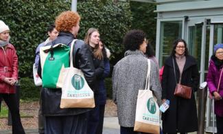 alt="A group of people standing outside the entrance of the Fitzwilliam Museum facing a tour guide."