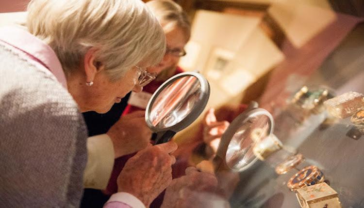 a lady looking at an object with a magnifying glass