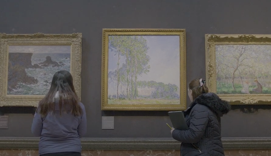 Two young people stand in front of Monet paintings at the Fitzwilliam Museum.