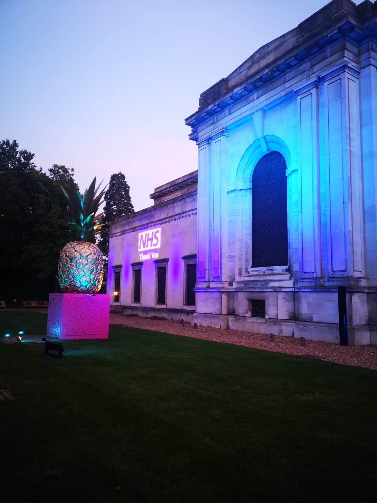 The Fitzwilliam Museum's Courtyard Entrance lit up in blue, with the NHS Logo and Thank You projected onto the wall