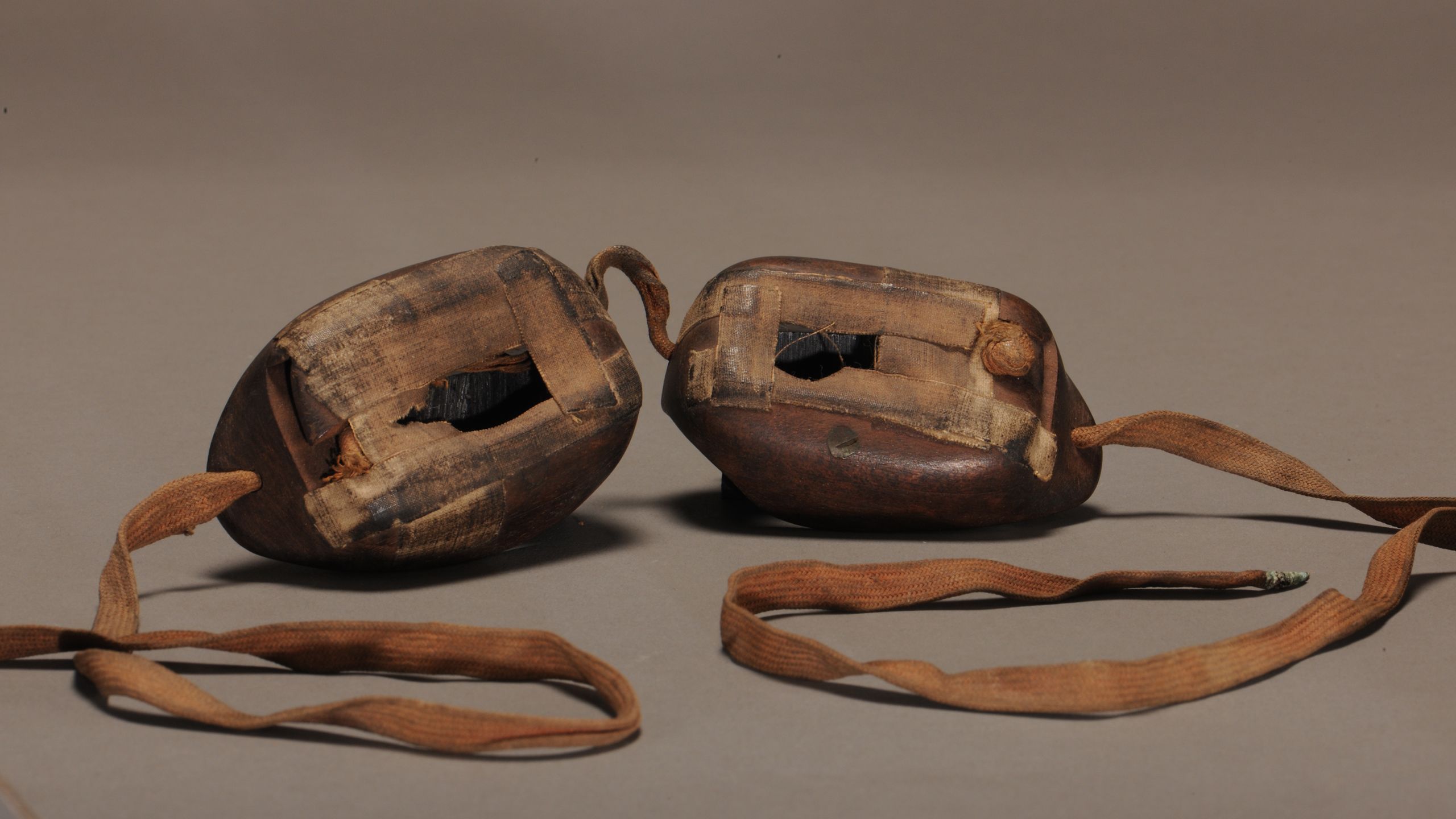 Wooden goggles with leather strap, taped up around the eye holes to limit amount of sunshine reaching the wearer's eyes.
