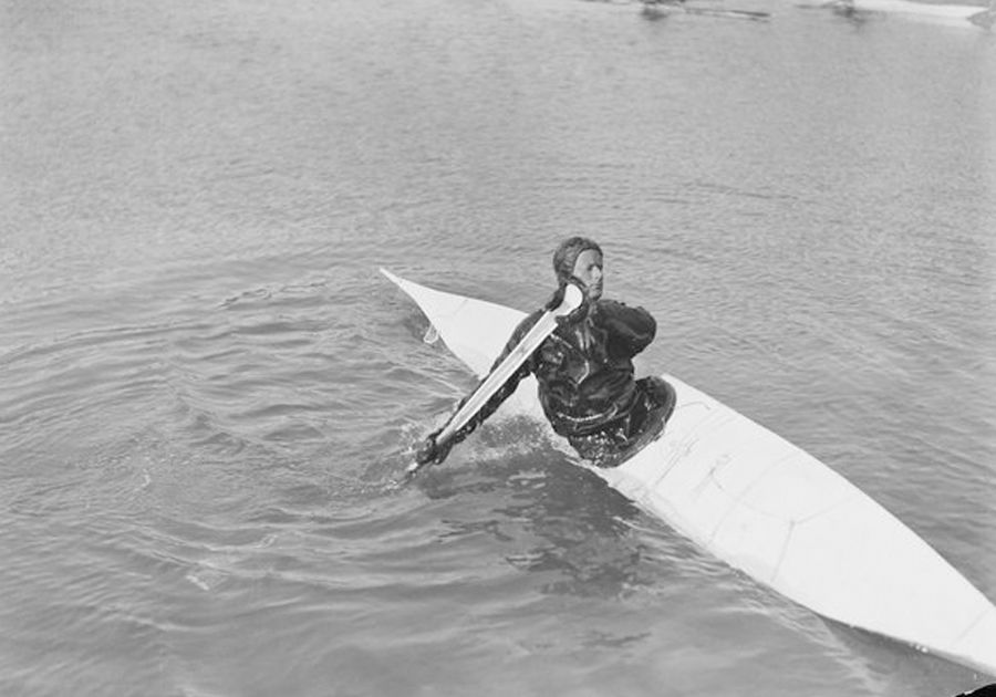 Gino Watkins in a kayak on the water preparing to roll over.