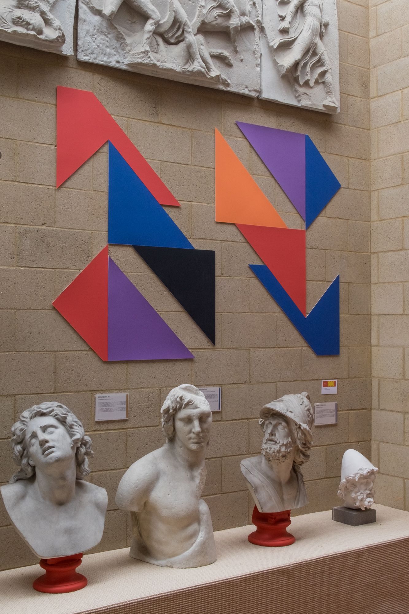 Coloured mountboard in the shape of the set square and various off cuts sit above busts and below reliefs