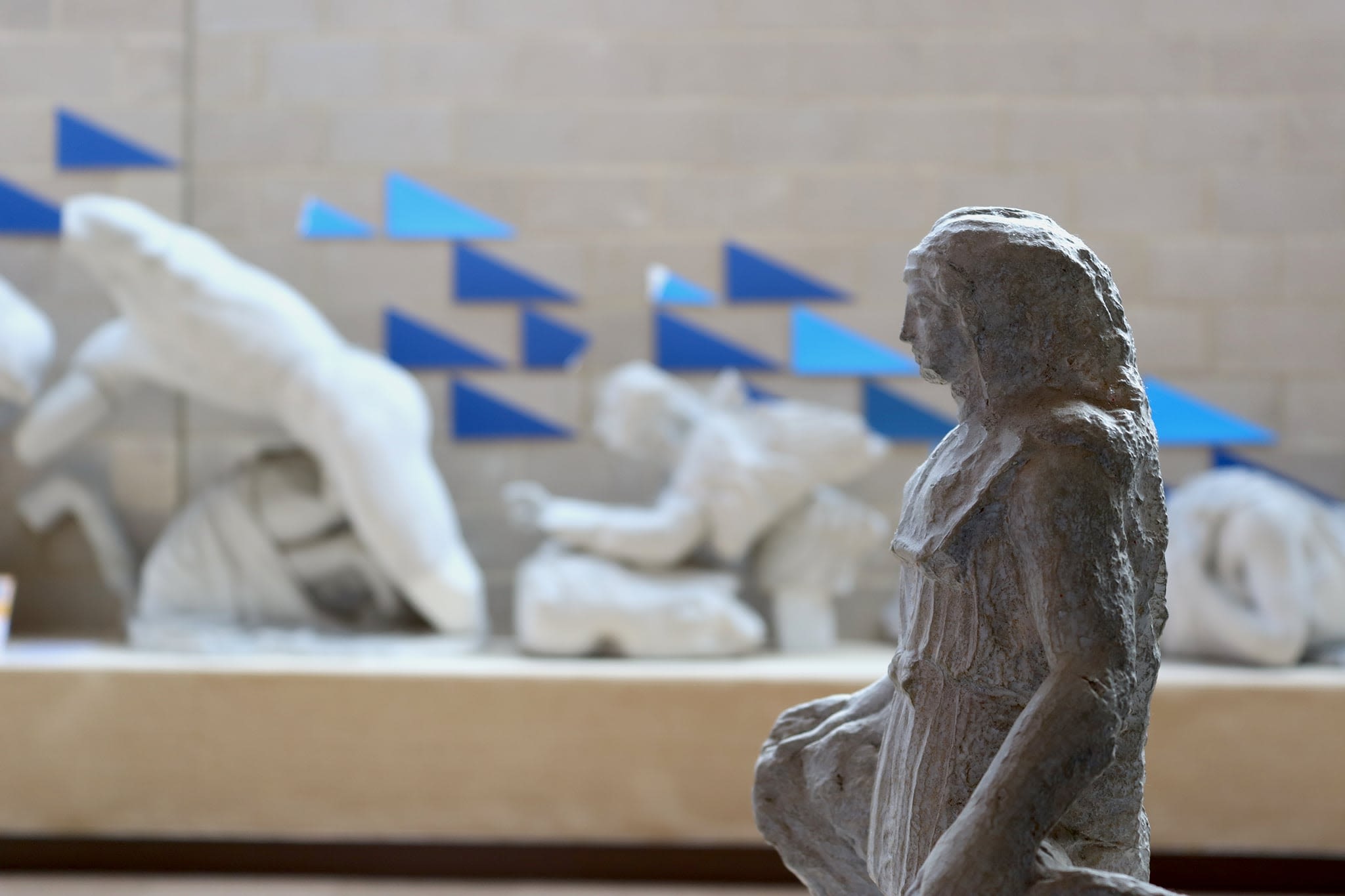 Blue triangle mountboards behind a statue in the foreground