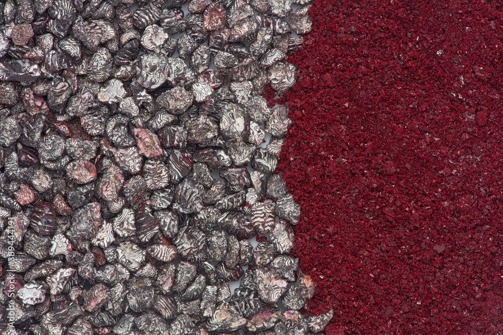 Top-down image: on the left half are many dried beetles, brown, white and red in colour, and on the right crushed down into a vivid red powder.