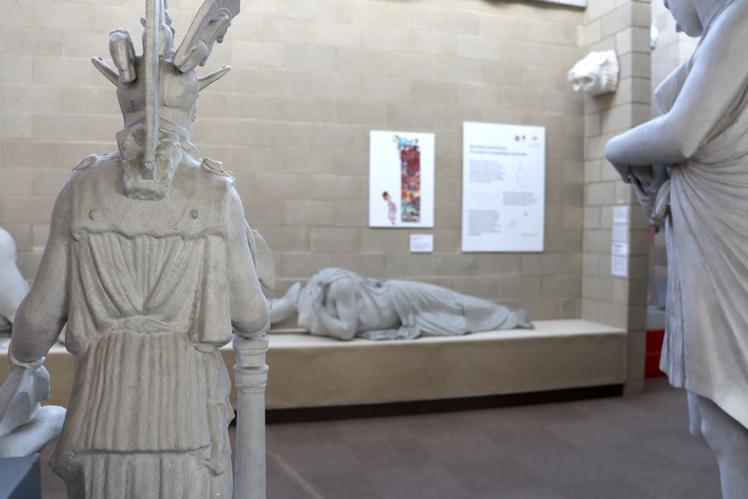 Photograph of the artwork 'Stratigraphy' positioned above a plaster cast of a figure lying on their stomach.