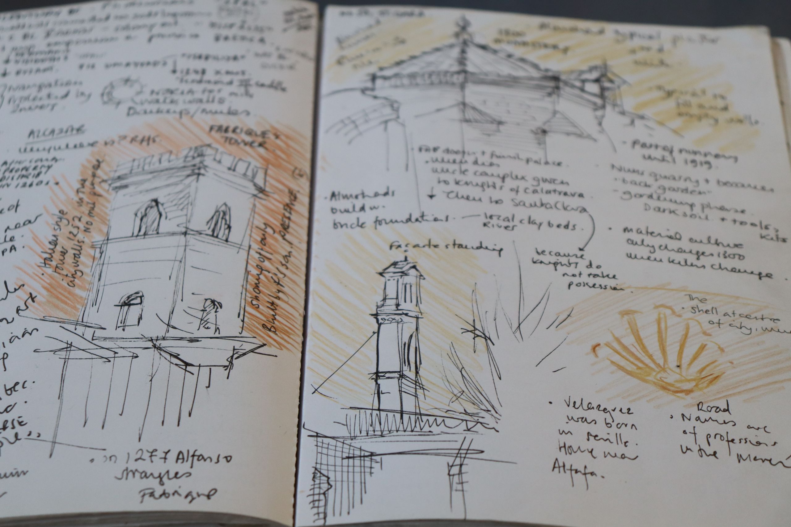 An inside view of a sketchbook. There are drawings of buildings annotated with lot of handwritten notes.