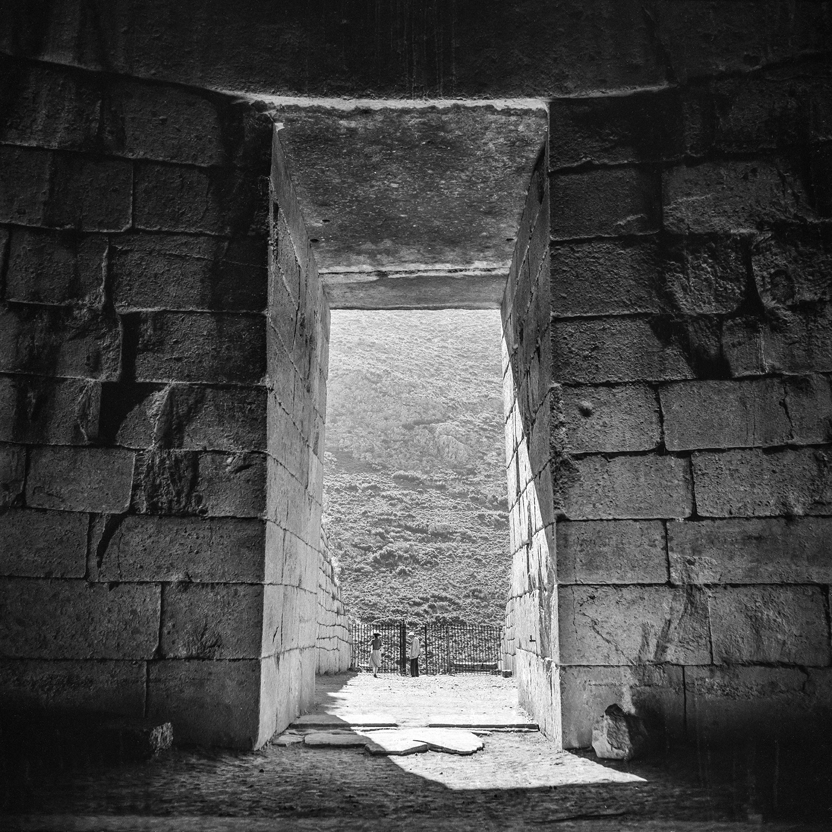 View from inside an ancient building, looking out to people standing outside