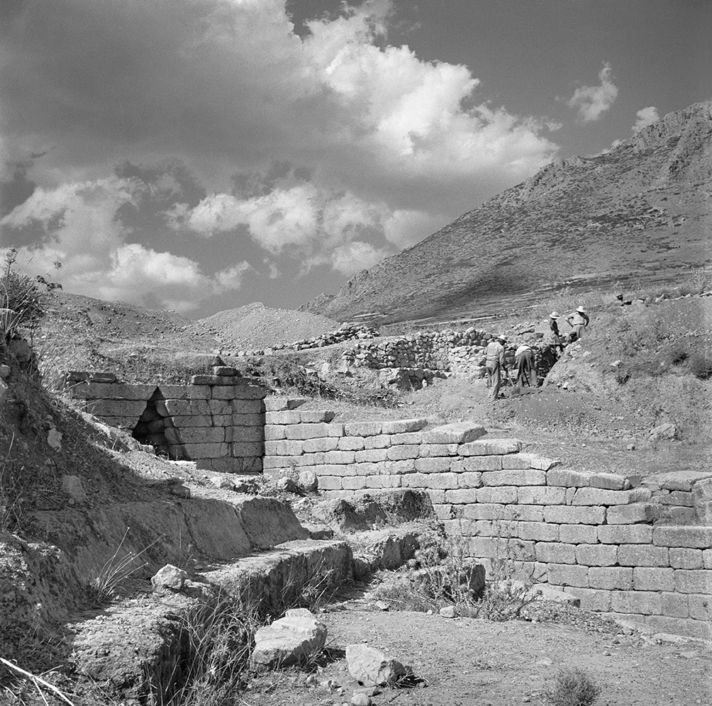 Men work behind ancient architectural remains