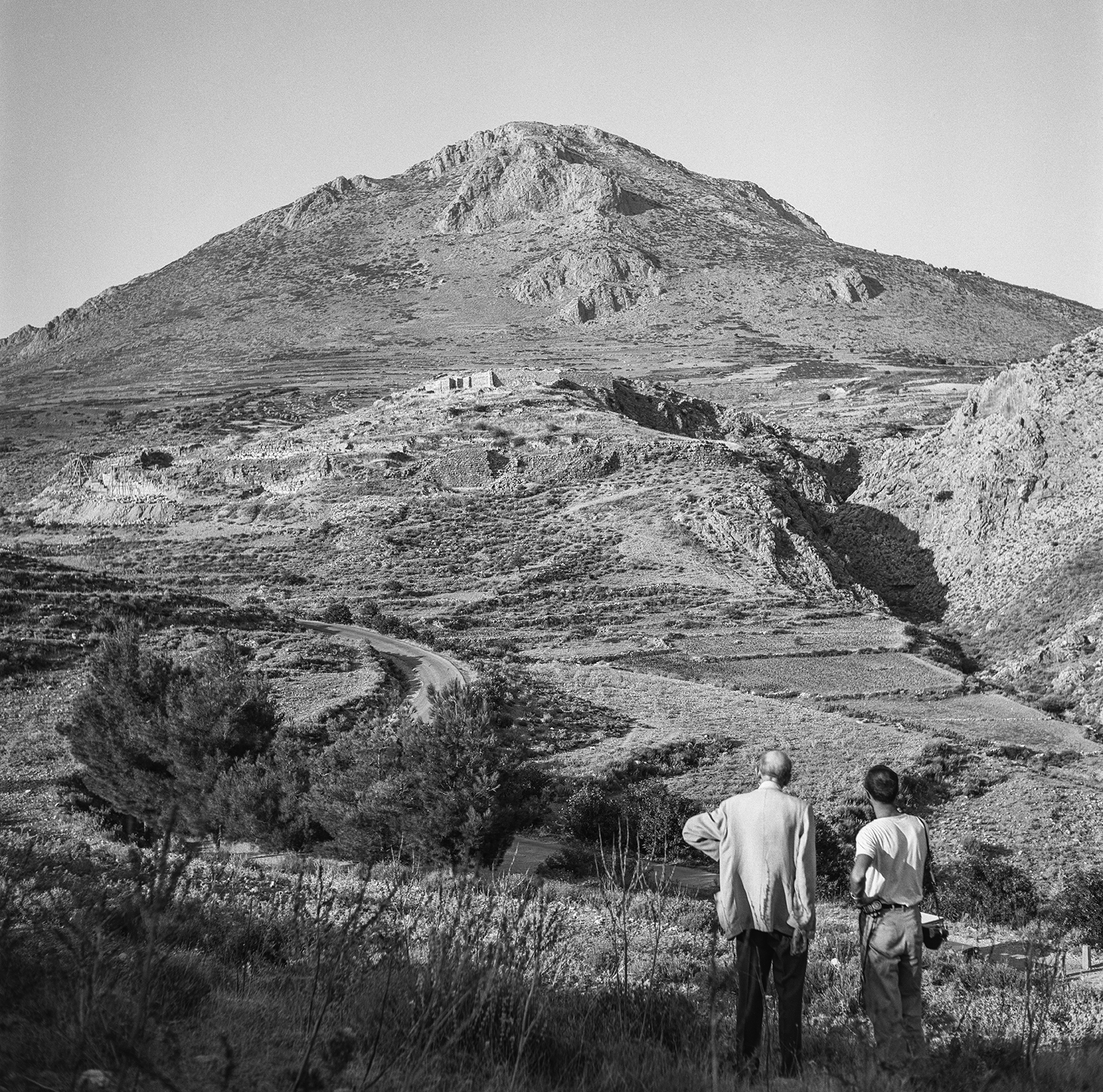 Two men look towards a mountain